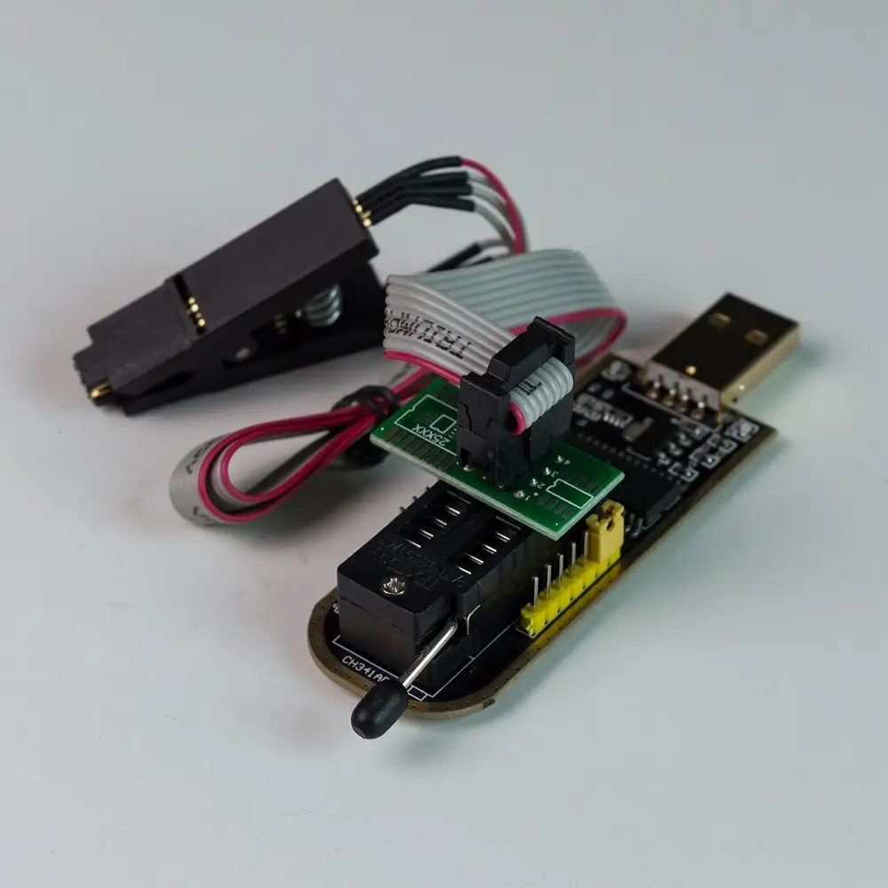 CH341A USB hardware programmer connected with SOIC8 test clip for in-circuit SPI flash recovery
