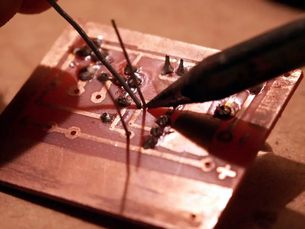 Micro-soldering station desoldering an 8-pin SPI flash chip from a laptop logic board